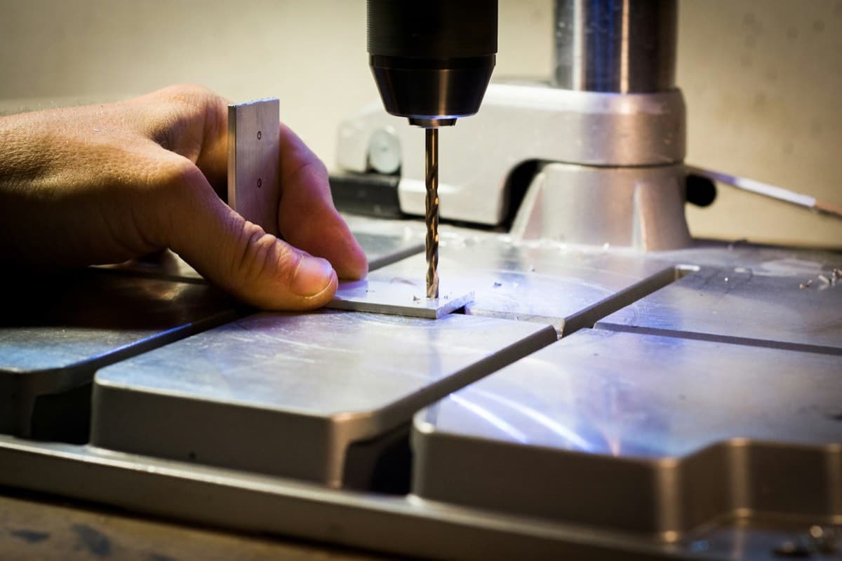 Main d'artisan travaillant le métal à l'atelier