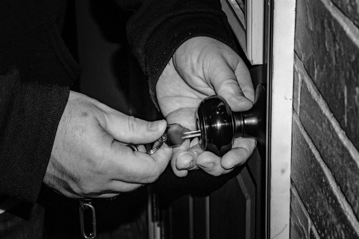 Main qui tourne une clé dans une serrure de porte
